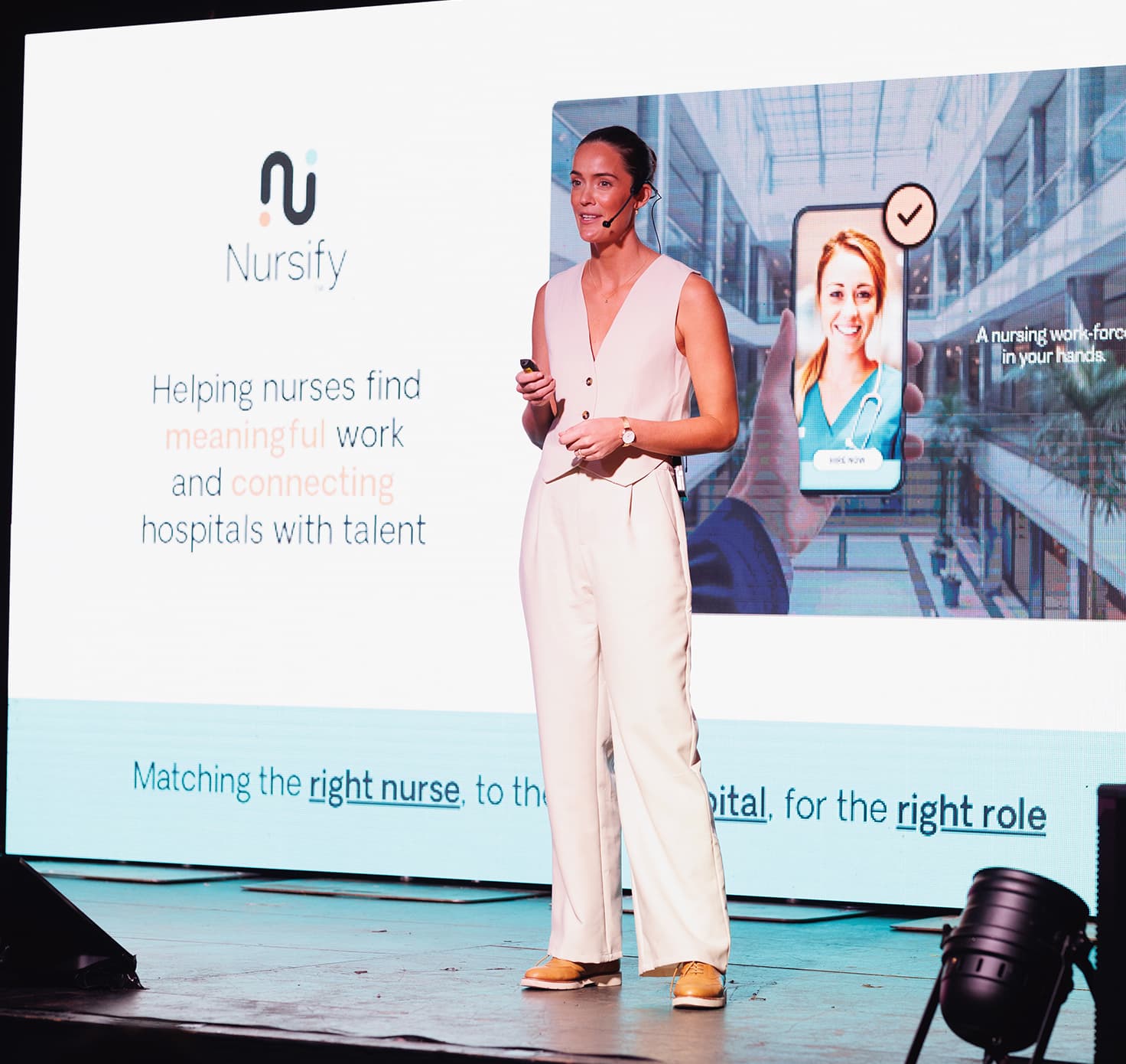 Girl on stage presenting on Lumina business.