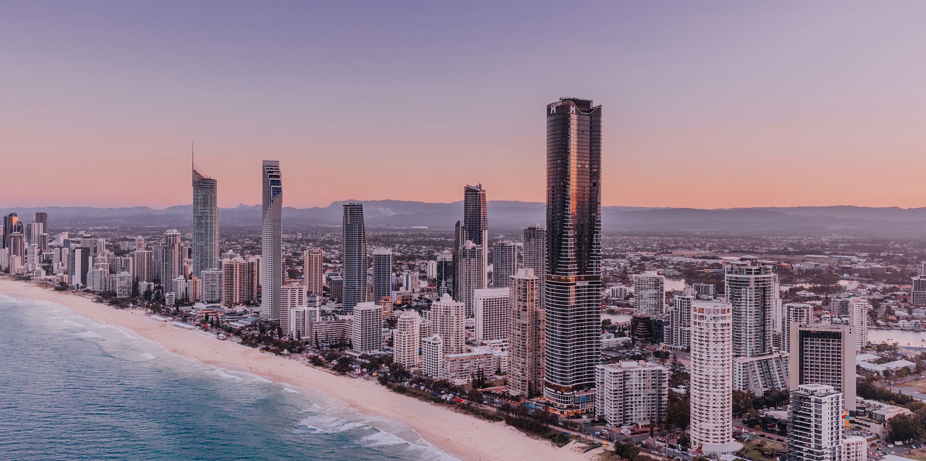 Gold Coast city skyline and beachfront at dusk.