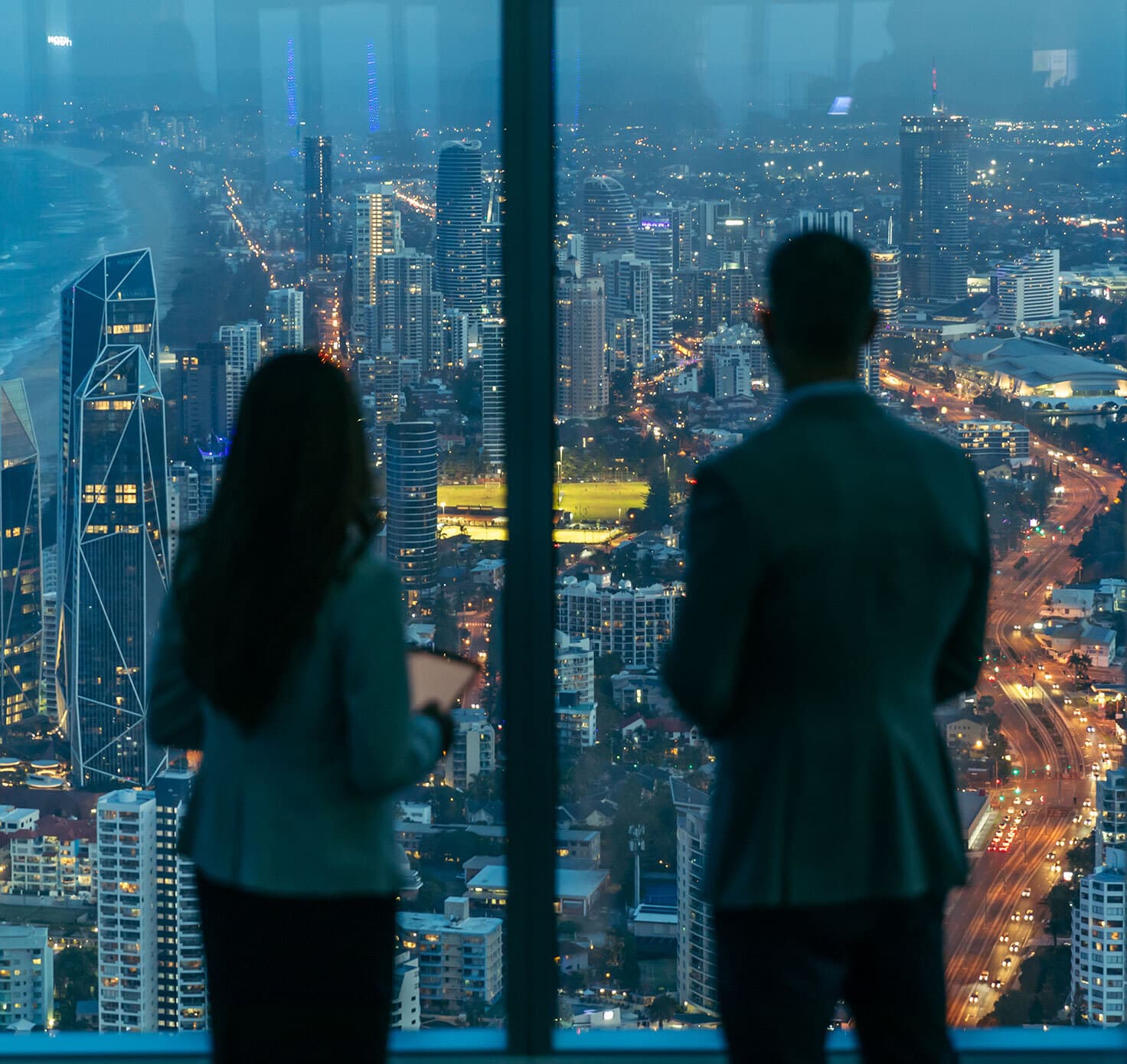 Professionals look outside the window of Q1, Surfers Paradise at the city below.