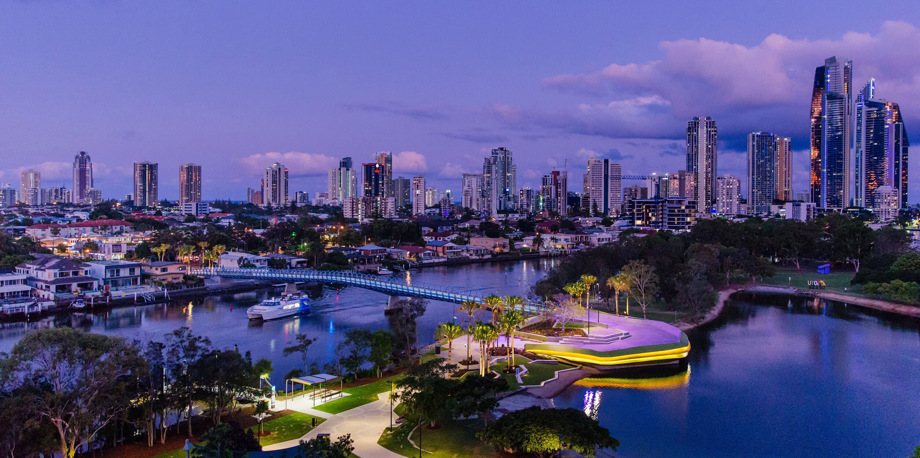 Evandale Lake and Green Bridge lit up at night with high-rises behind.