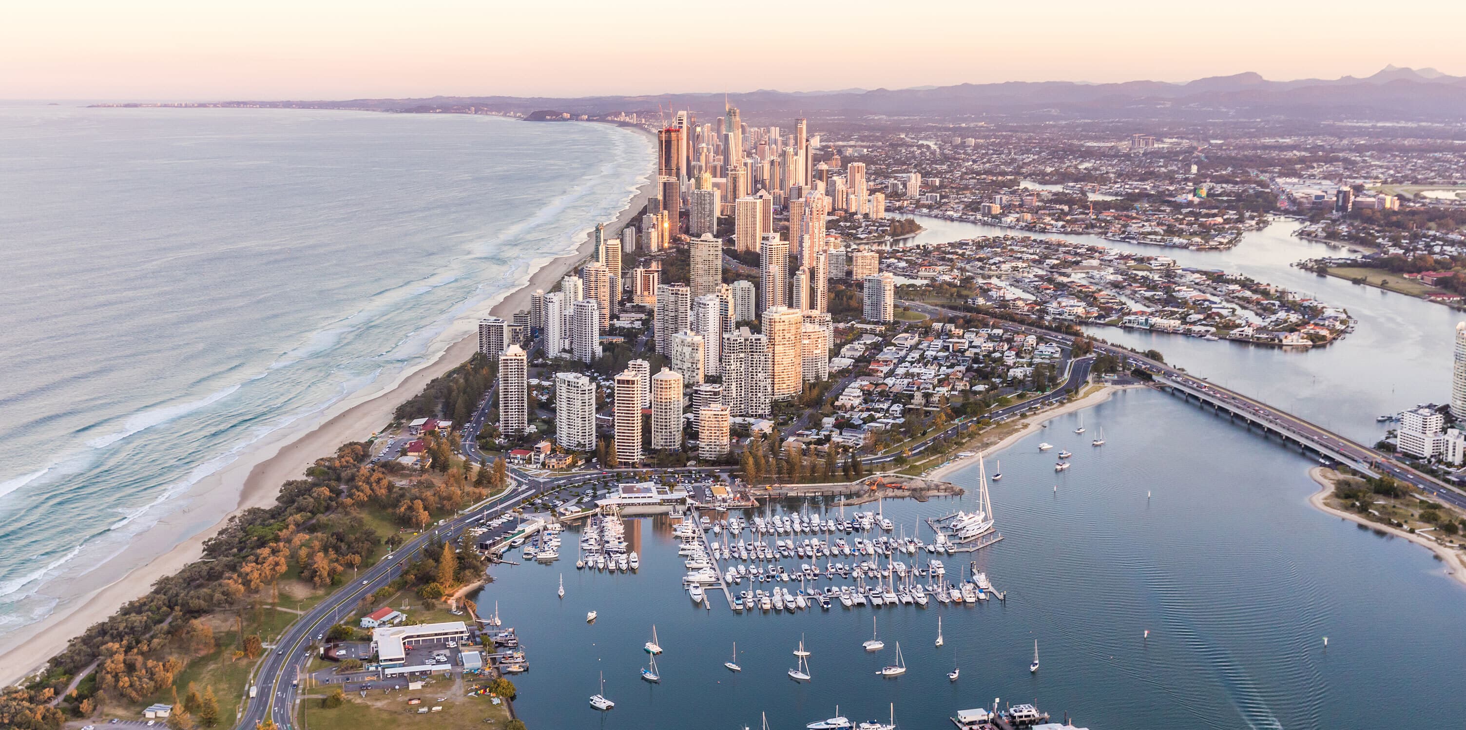 Boats on the water at Carter's Basin with the city behind at sunset.
