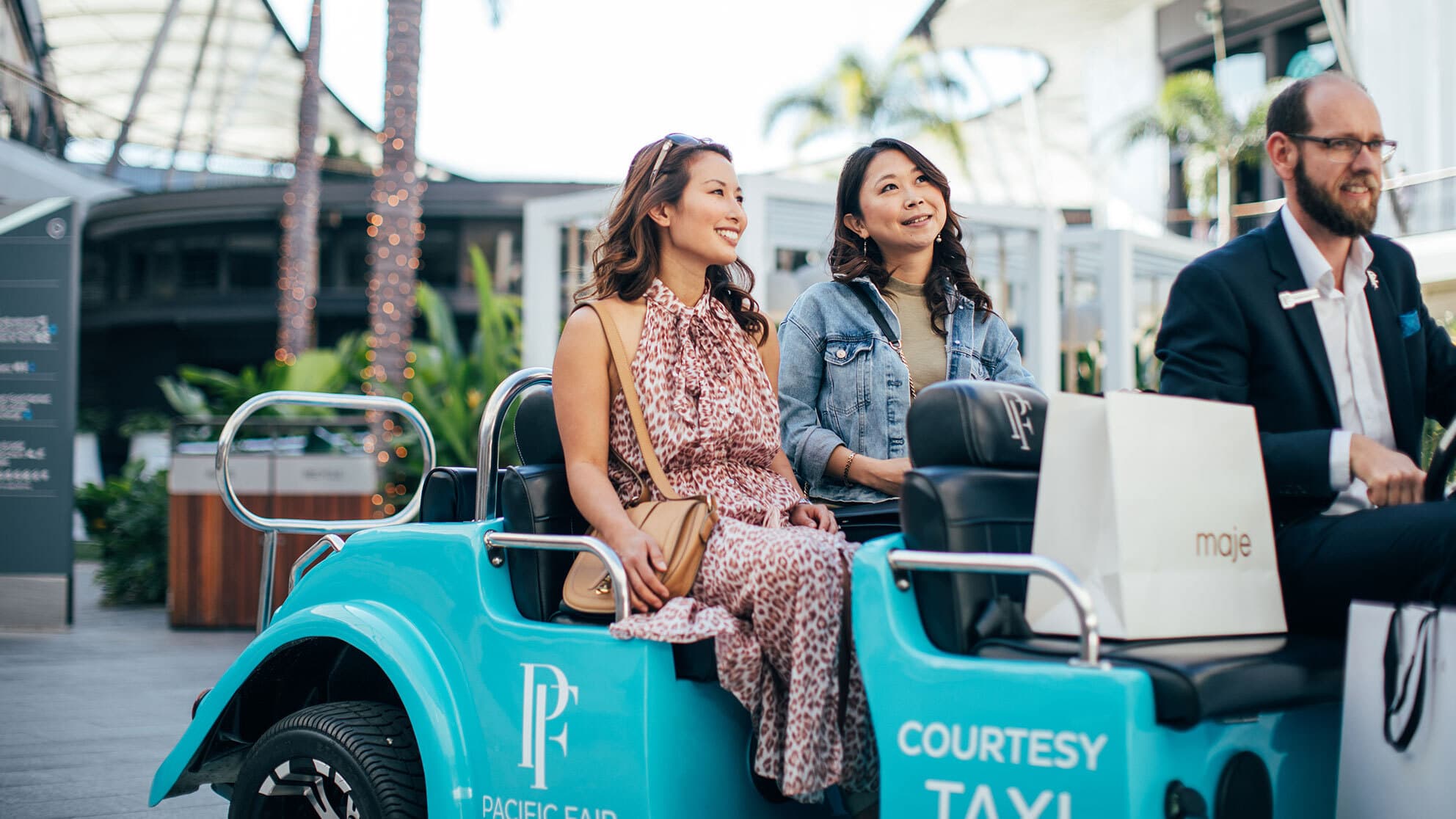 Two ladies are passengers in the courtesy taxi at Pacific Fair Shopping Centre.