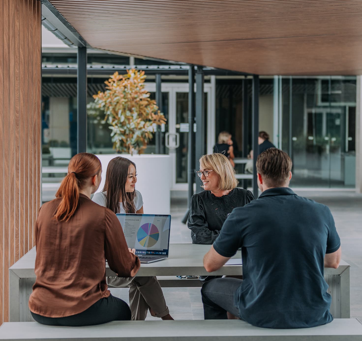 A group of professional people sit together in conversation.